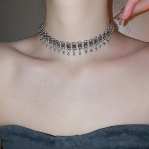 Detail of silver metallic choker featuring intricate hollow mesh and beaded tassel fringe