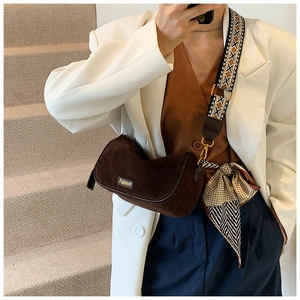 Detail of dark brown suede pillow bag with a geometric pattern wide shoulder strap