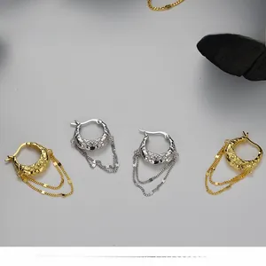 Detail of S925 silver lava texture earrings with long metal tassels in gold and silver