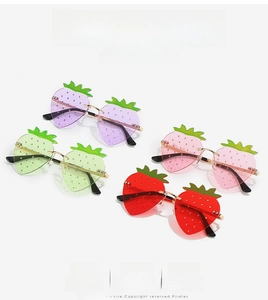 Detail of strawberry-shaped rimless sunglasses in multiple colors with golden metal temples