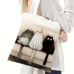 Close-up of a canvas tote bag featuring cute cartoon cats illustration on model shoulder