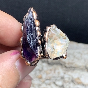 Macro shot of vintage dual raw amethyst stones with antique bronze claw setting details