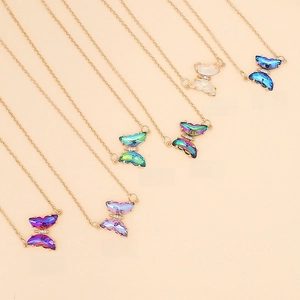 Detail of butterfly pendants in deep purple, green and blue with golden link chains