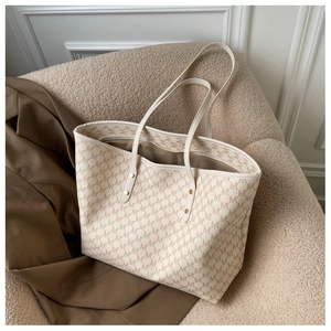Dettaglio della stampa monogramma e del materiale morbido sulla borsa tote beige