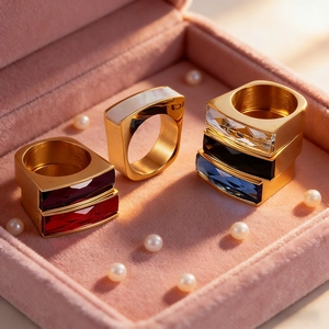 Luxurious gold square rings with colorful gemstones displayed in a velvet jewelry box