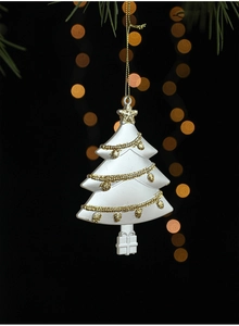 Gros plan d'un ornement de sapin de Noël blanc avec paillettes dorées et cordon festif