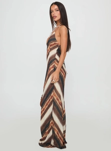 Detail view of the tie-dye pattern and slim fit cut of a long backless V-neck dress