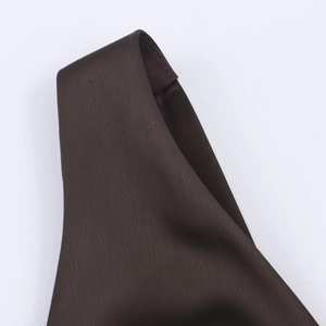 Close-up of hollow embroidery and fine stitching on the brown midi dress strap
