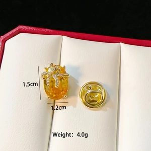 Detail of gold brooch with yellow gemstone and bow design, size 1.5cm x 1.2cm