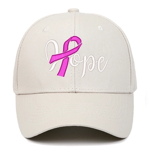 Détail de la broderie Hope et du ruban rose sur une casquette en coton crème
