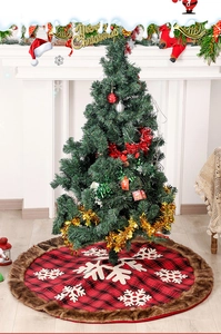 Detail of red plaid Christmas tree skirt with white snowflakes and faux fur trim