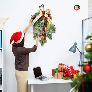 Christmas swag with snow-tipped pine needles, red berries, cones and warm LED lights