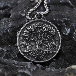 Macro shot of vintage silver Viking Tree of Life pendant with embossed details on rock background
