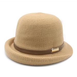 Close-up of khaki woven hat with dark brown band and gold metal buckle detail