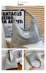 Close-up of a silver pleated tote bag with a metal butterfly and chain details