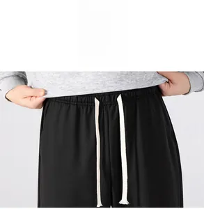 Detail of men's elastic waist black casual pants with adjustable white drawstrings