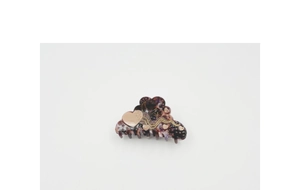 Detailed close-up of dark purple marble acetate hair claw with gold heart and moon stars