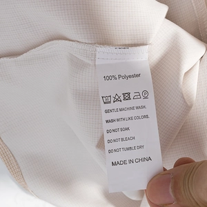 Détail de l'étiquette d'entretien pour robe en dentelle polyester avec instructions de lavage
