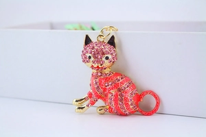 Detail of pink crystal lucky cat keychain with gold finish and enamel patterns