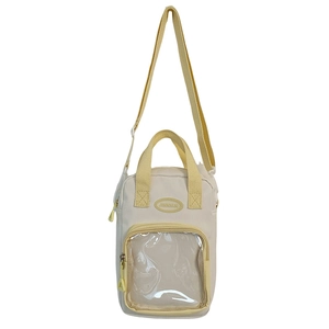 Detail of cream canvas ita bag with adjustable yellow strap and transparent PVC window