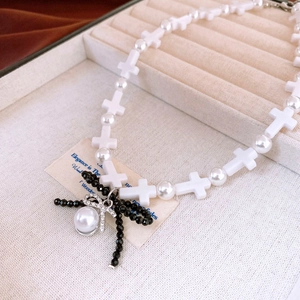 Detail of cross beads and black beaded bow pendant with large pearl inlay necklace