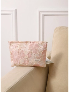 Pink embossed floral makeup bag with large capacity and jacquard texture on sofa