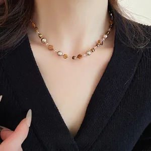 Halskette mit Tigerauge und Perlen an einem weiblichen Modell mit goldenen Akzenten