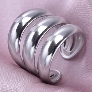 Macro shot of silver-tone polished triple-layered wide ring on purple silk fabric