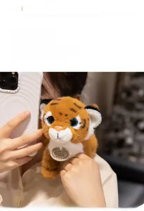 Detail of plush tiger toy with soft fur, blue eyes and round branded chest tag