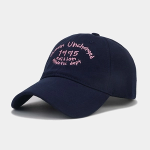 Dettaglio del ricamo rosa su un cappello di cotone blu scuro con visiera curva
