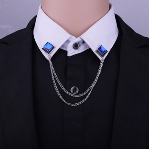 Close-up of geometric blue gem collar pins with double silver chains on a dress shirt