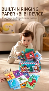 Detail of baby tissue box toy featuring plush fabric Christmas patterns and crinkle paper
