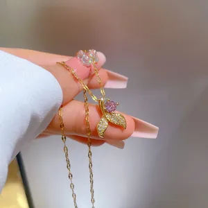 Dettaglio del pendente a coda di pesce con gemma rosa e zirconi in placcatura oro