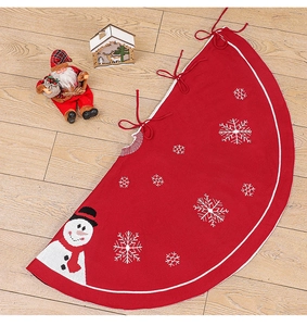 Détail du cache-pied de sapin rouge tricoté avec broderie bonhomme de neige et flocons