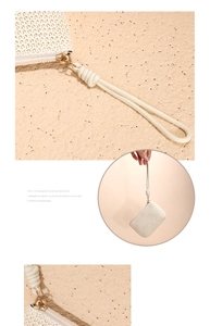 Detail of minimalist cream straw woven coin purse with gold zipper and braided wrist strap