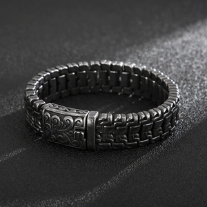 Detailed close-up of dark grey vintage titanium steel bracelet with floral engraving