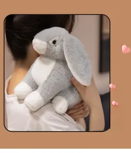 Close-up of soft plush rabbit with grey and white fur being hugged by a person