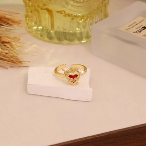 Close-up of vintage gold heart ring with crown detail on a white textured stone base