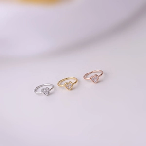 Detailed macro view of heart-shaped zircon rings in silver, gold, and rose gold finishes