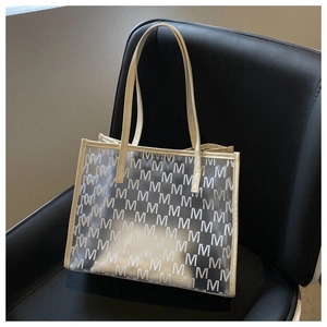 Detailed macro view of beige leather handles and translucent frosted tote with M pattern