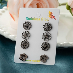 Detailed view of four pairs of black matte stainless steel floral stud earrings set