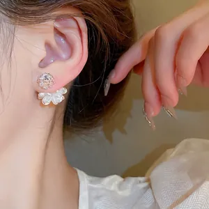 Elegante gewebte Blumen-Ohrstecker mit Perlen- und Zirkon-Details am Frauenmodell