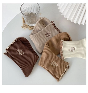 Detail of coffee brown cotton socks featuring delicate flower embroidery and ruffled edges