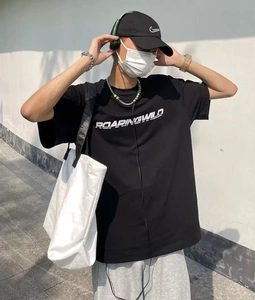 Nahaufnahme eines schwarzen Baumwoll-T-Shirts mit weißem ROARINGWILD-Schriftzug