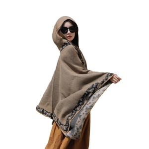 Ethnic knit hooded poncho in brown with golden patterns and decorative trim for travel