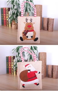 Détail de sacs cadeaux de Noël en lin avec appliques 3D du Père Noël et de rennes