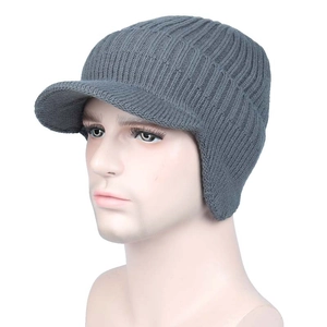 Detail of grey winter knit hat with visor and ear flaps on a model head stand