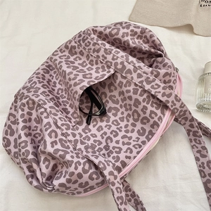 Dettaglio della borsa tote leopardata con cerniera rosa e texture in tessuto morbido