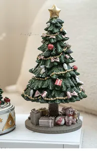 Close-up of resin Christmas tree carousel with bear figurine and gift box details