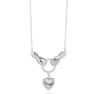 Detail of silver heart pendant with hand-holding ring design and fine engraving